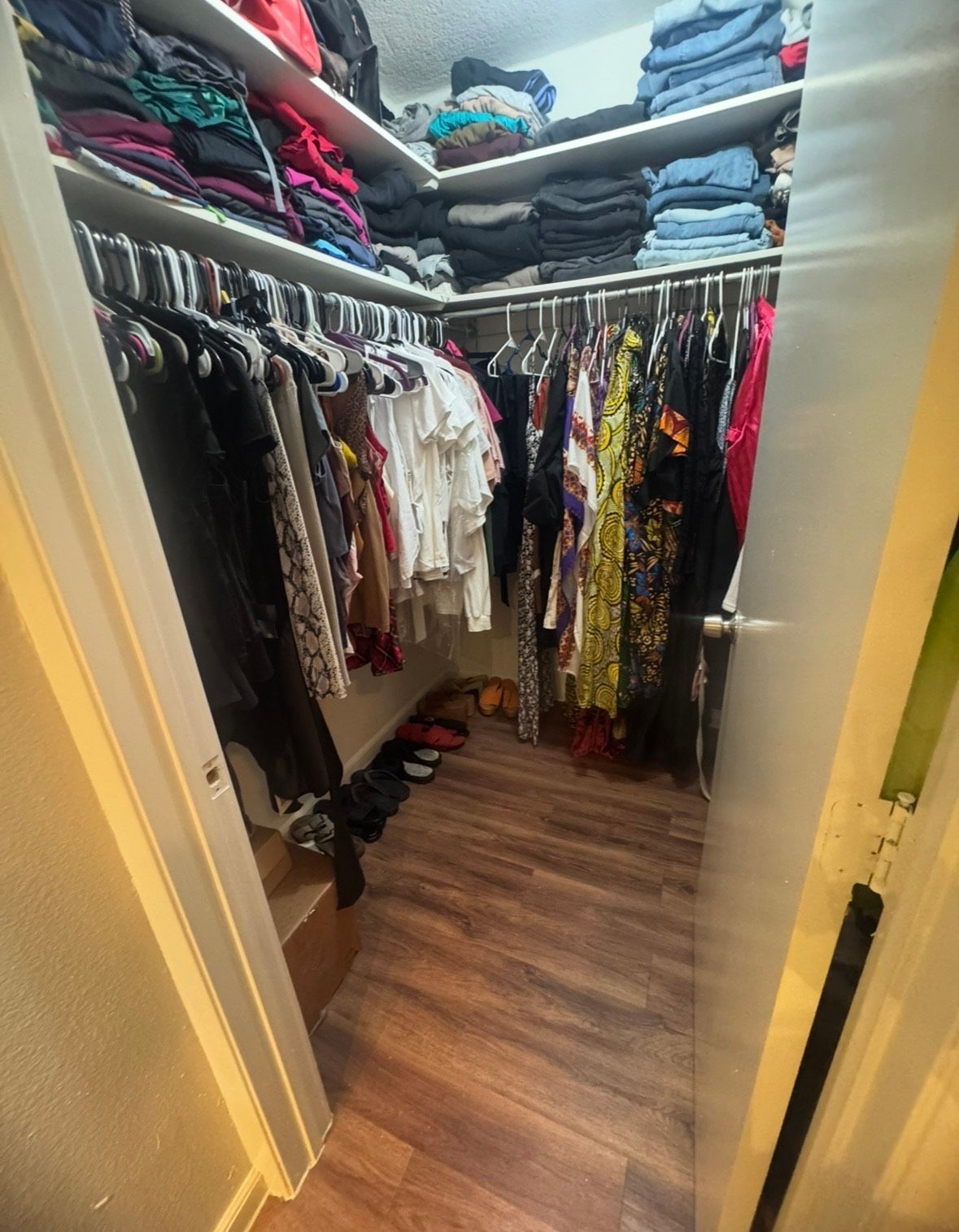 A bathroom with a walk in shower and a stool with towels on it.