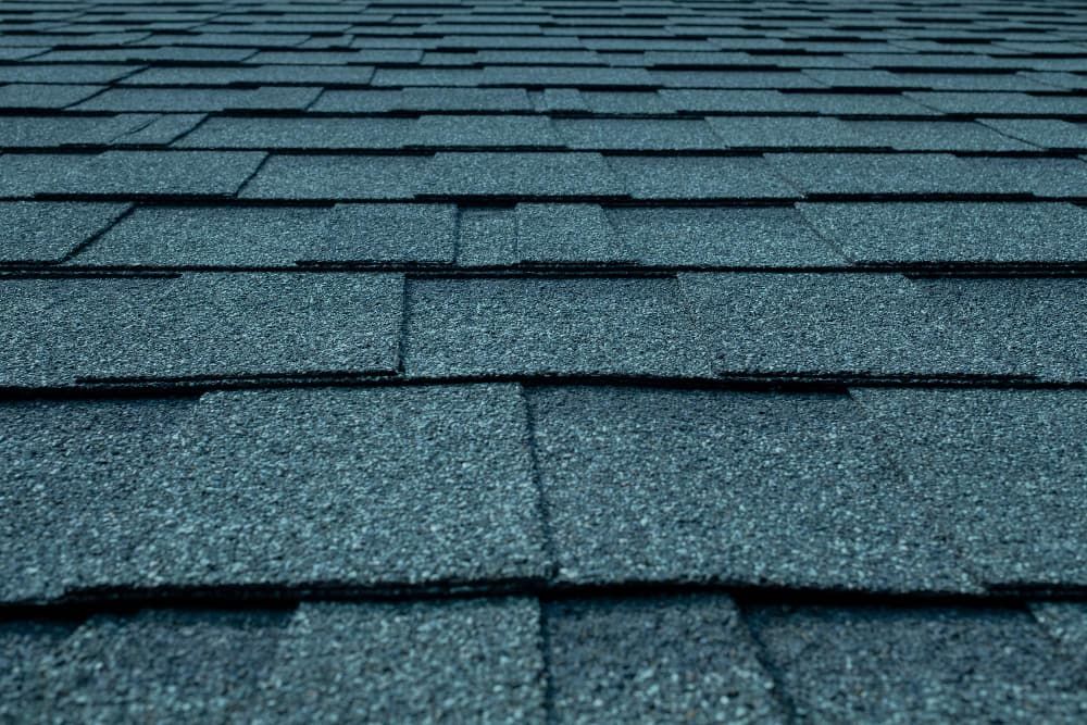 A close up of a roof with blue shingles.