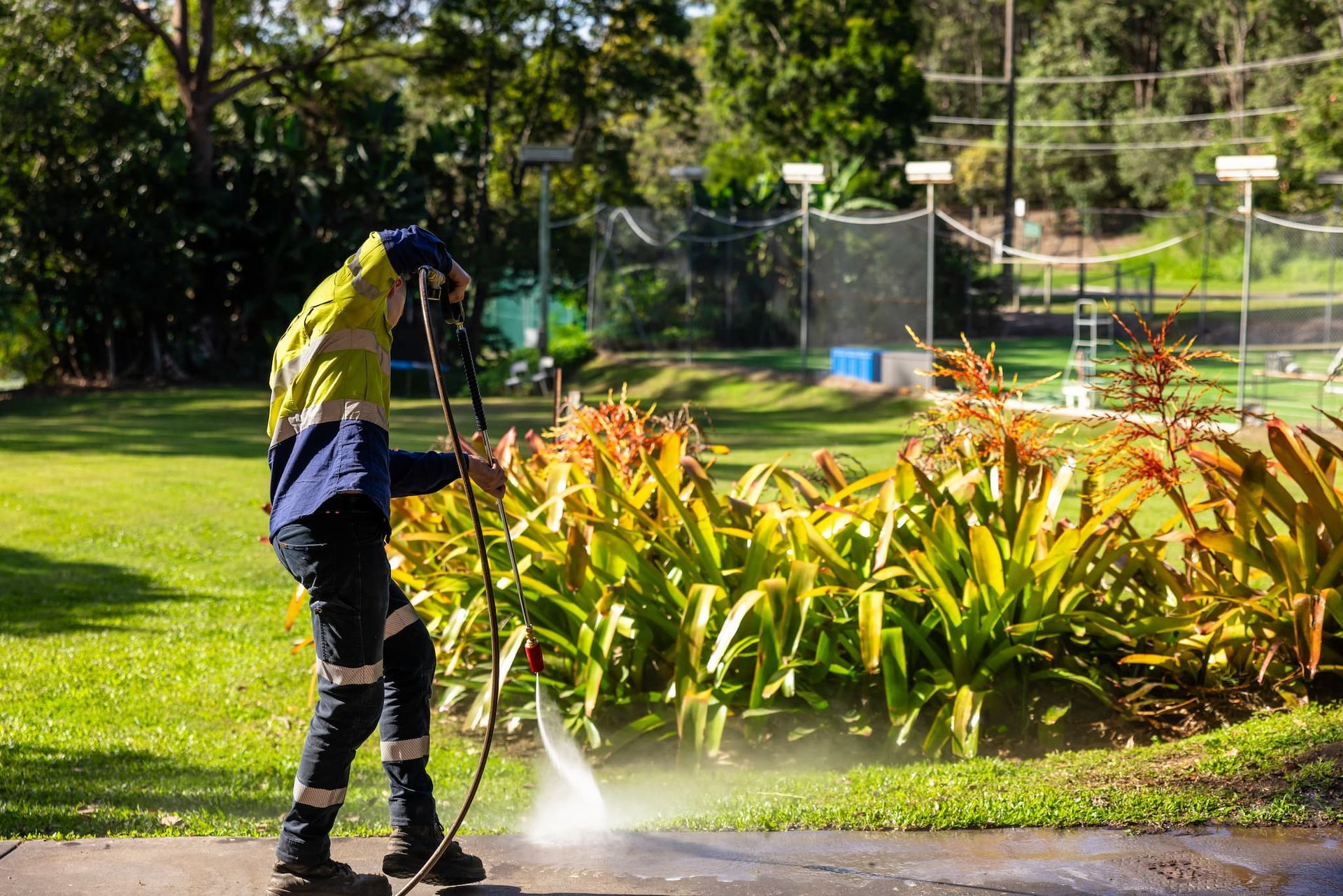 A man pressure washing a driveway.