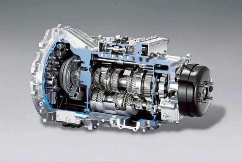 Cutaway view of a car transmission, revealing internal gears and mechanisms, with a blue tint highlighting some components.