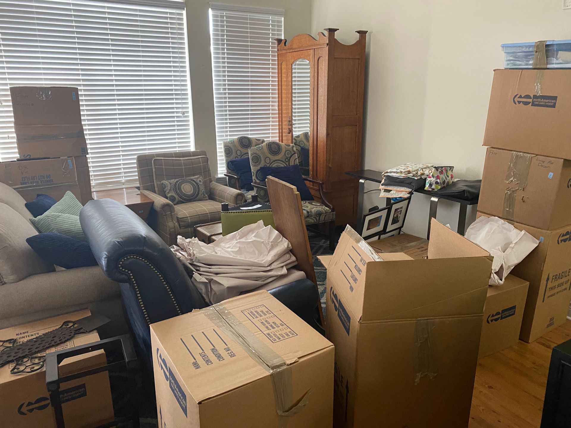 A living room filled with lots of cardboard boxes and furniture.