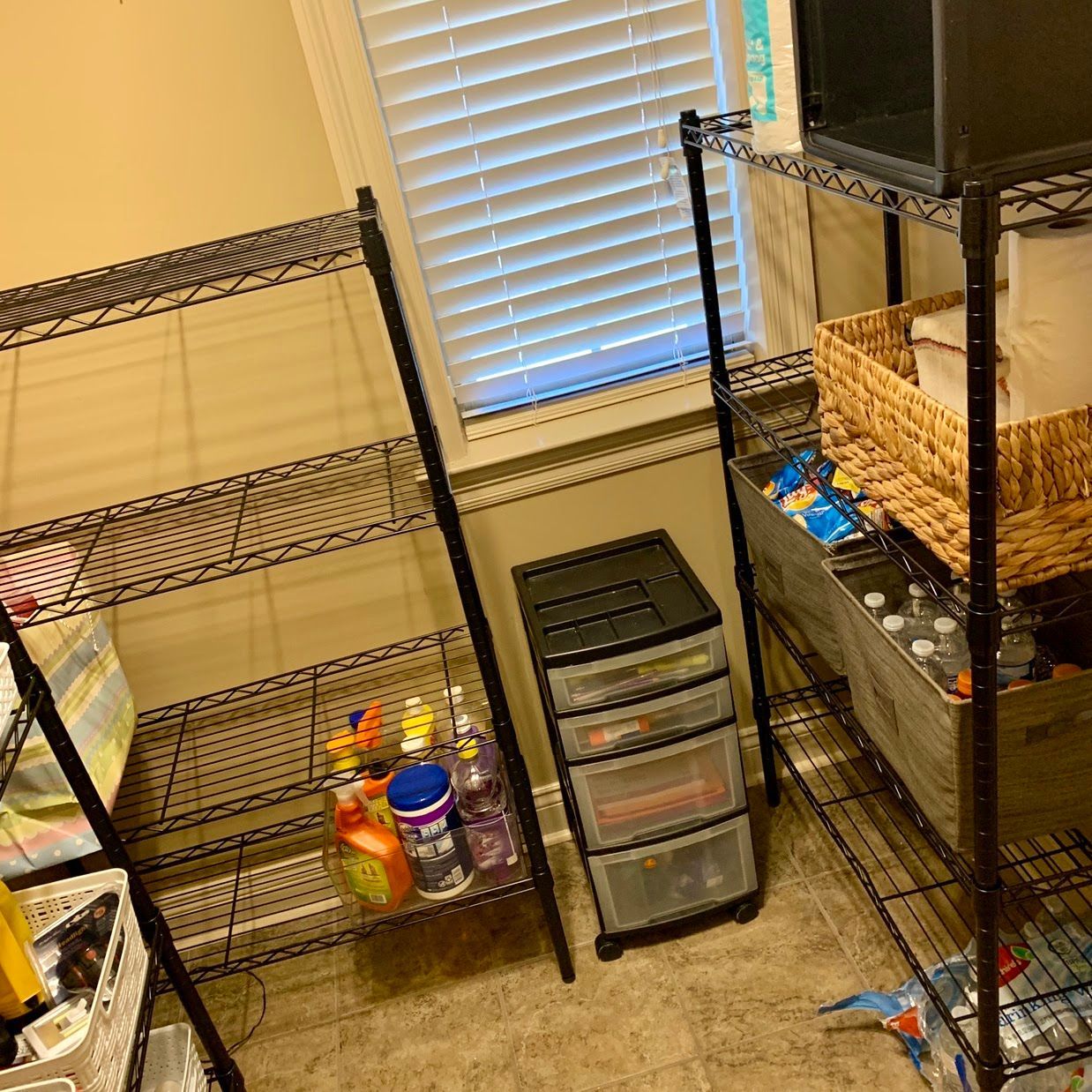 A room with a lot of shelves and drawers and a window.
