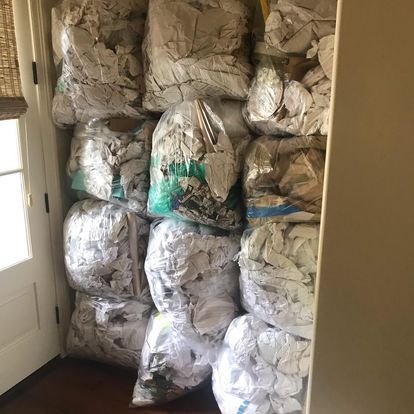 A bunch of bags of paper are stacked on top of each other in a room.