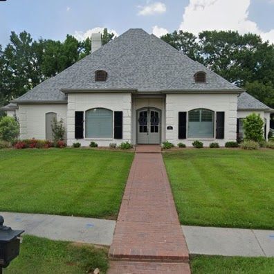 A white house with a brick walkway leading to it