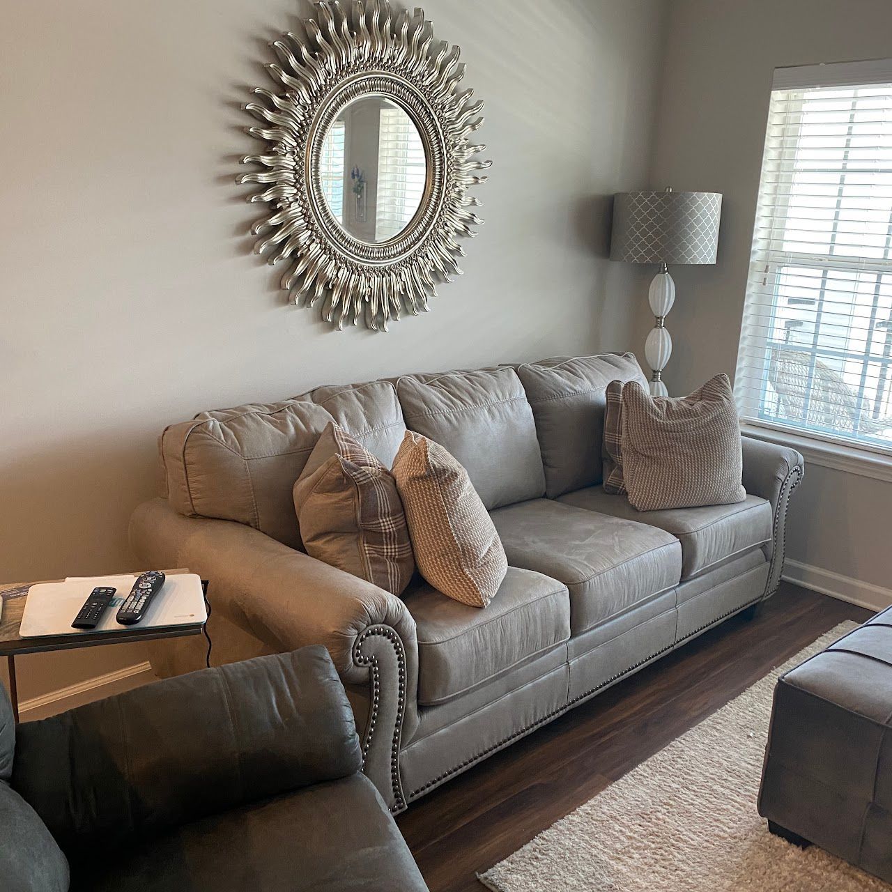 A living room with a couch and a mirror on the wall