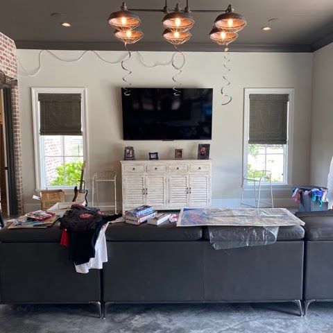 A living room with a couch and a flat screen tv on the wall.