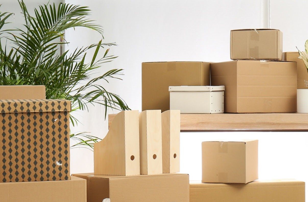 A bunch of cardboard boxes are stacked on top of each other in a room.