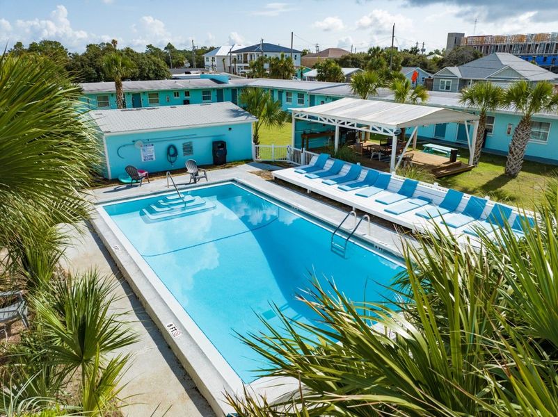 an aerial view of a large swimming pool surrounded by palm trees .