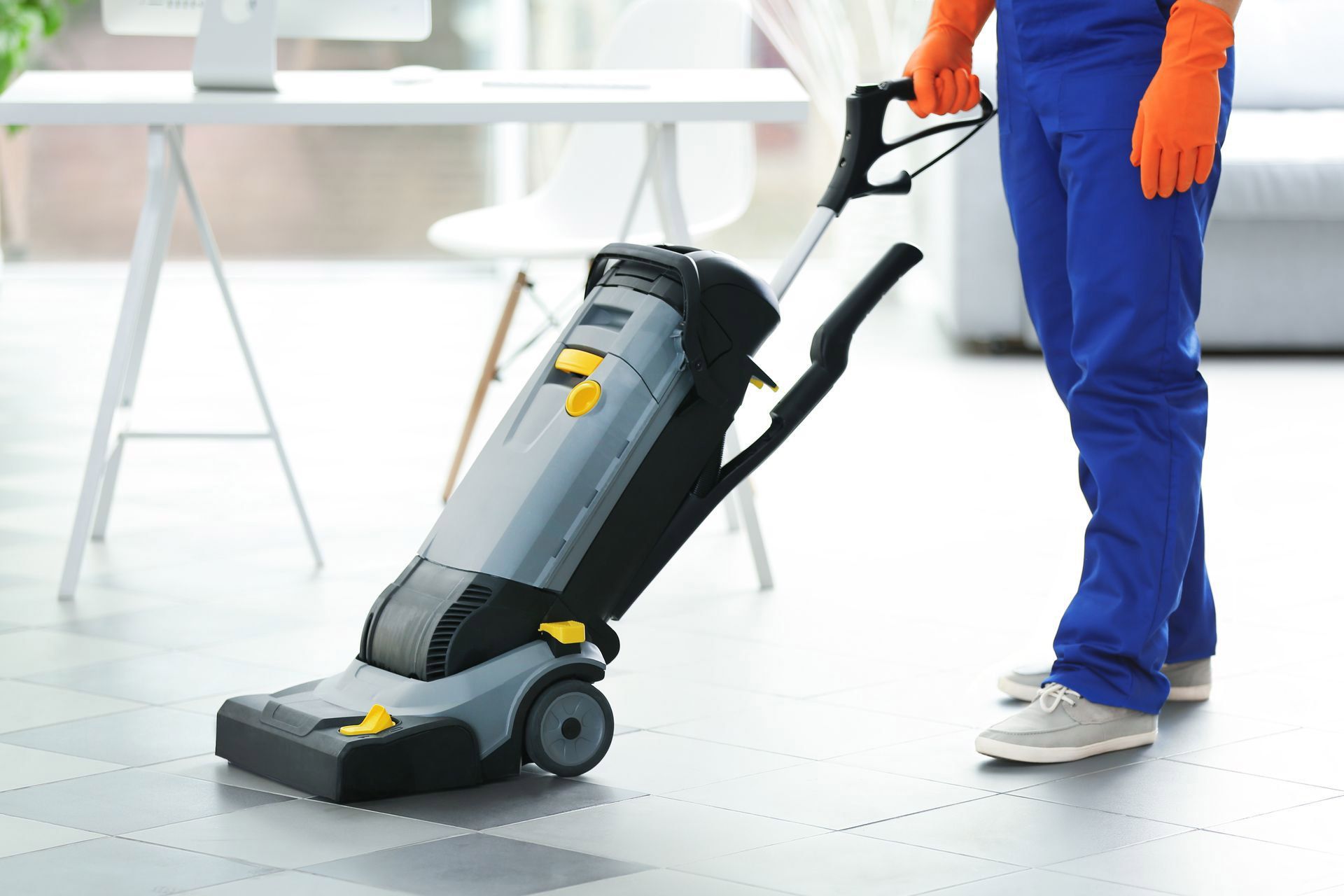 a man is cleaning the floor with a vacuum cleaner.