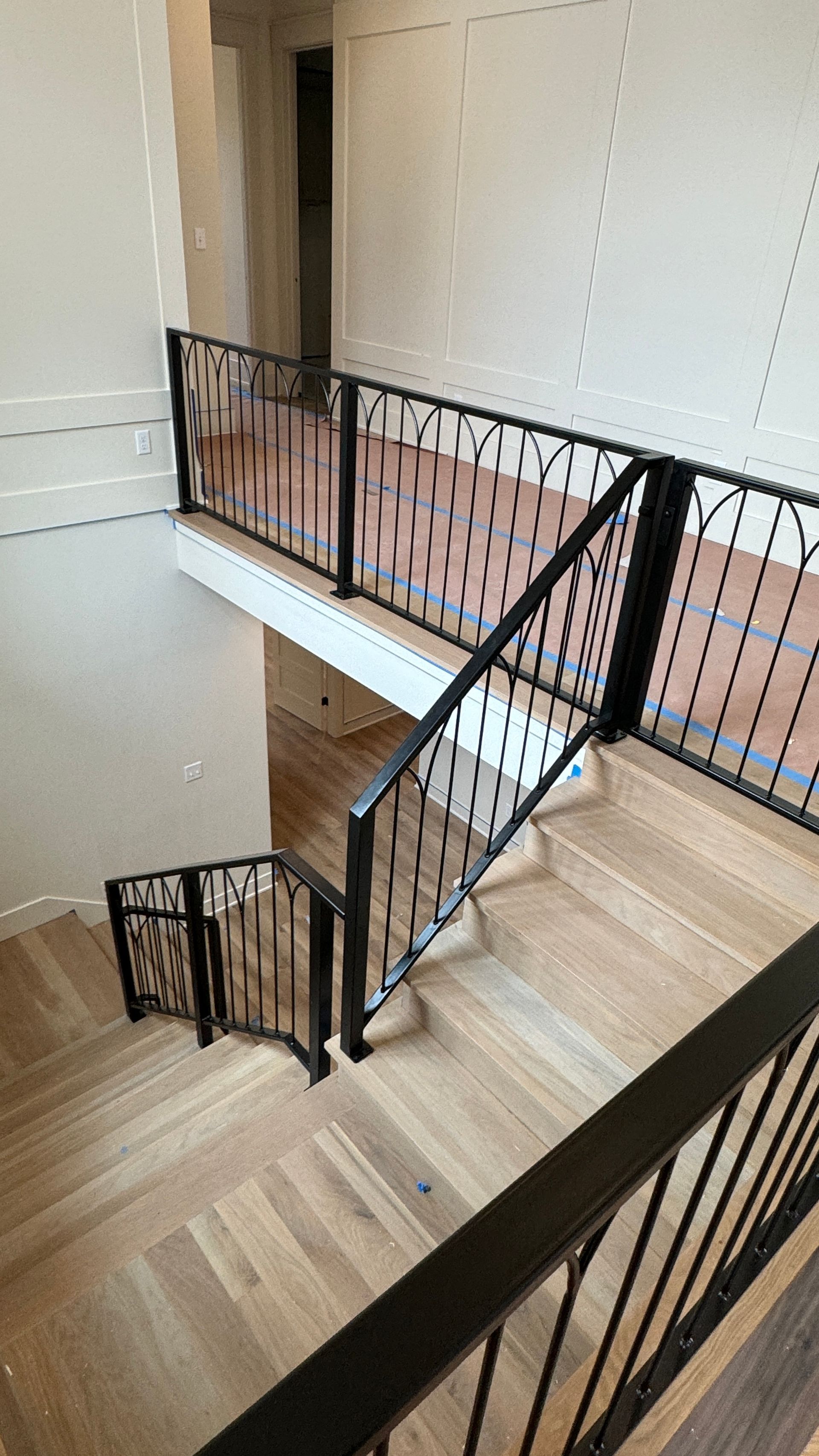 A view of a staircase from the second floor of a house under construction.