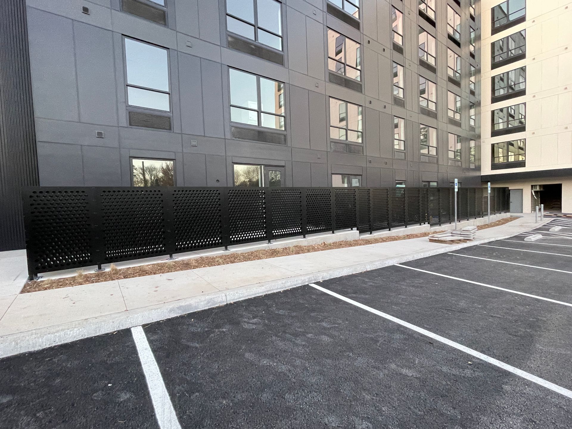A large building with a lot of windows and a parking lot in front of it.