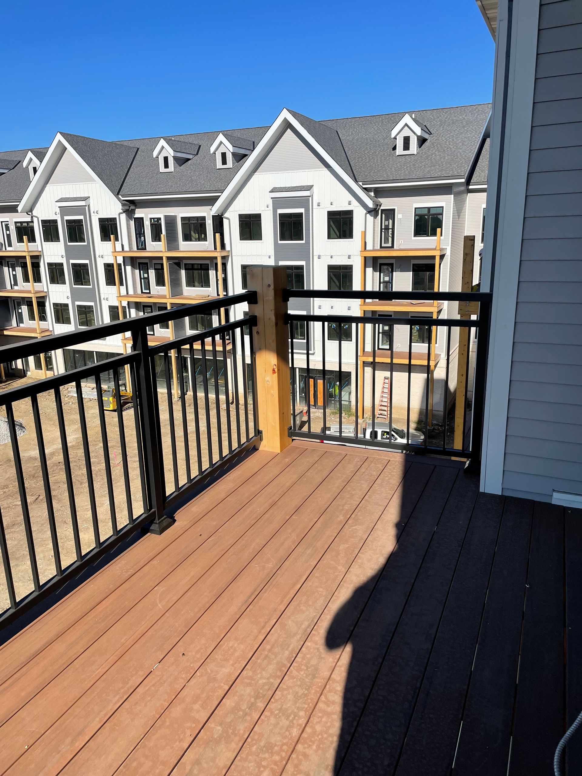 A balcony with a railing and a view of a building under construction