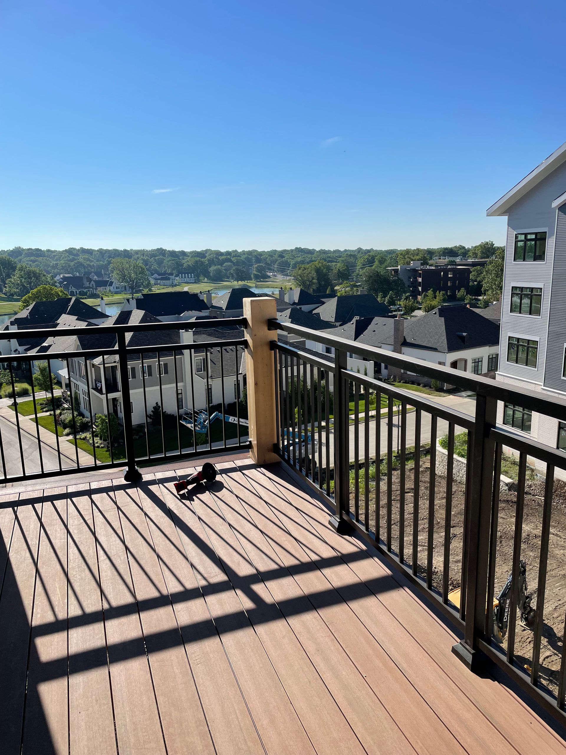 A balcony with a railing and a view of a residential area.