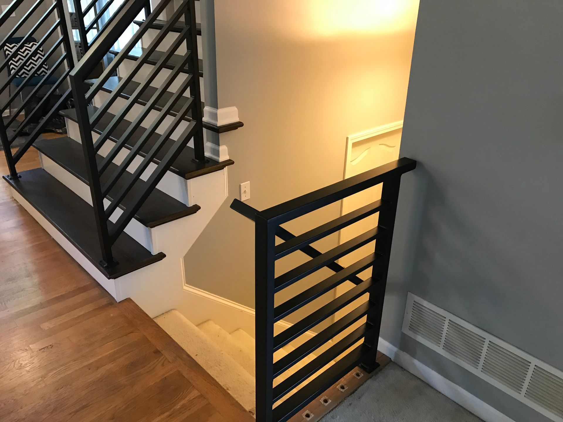 A staircase with a black railing and wooden steps in a house.