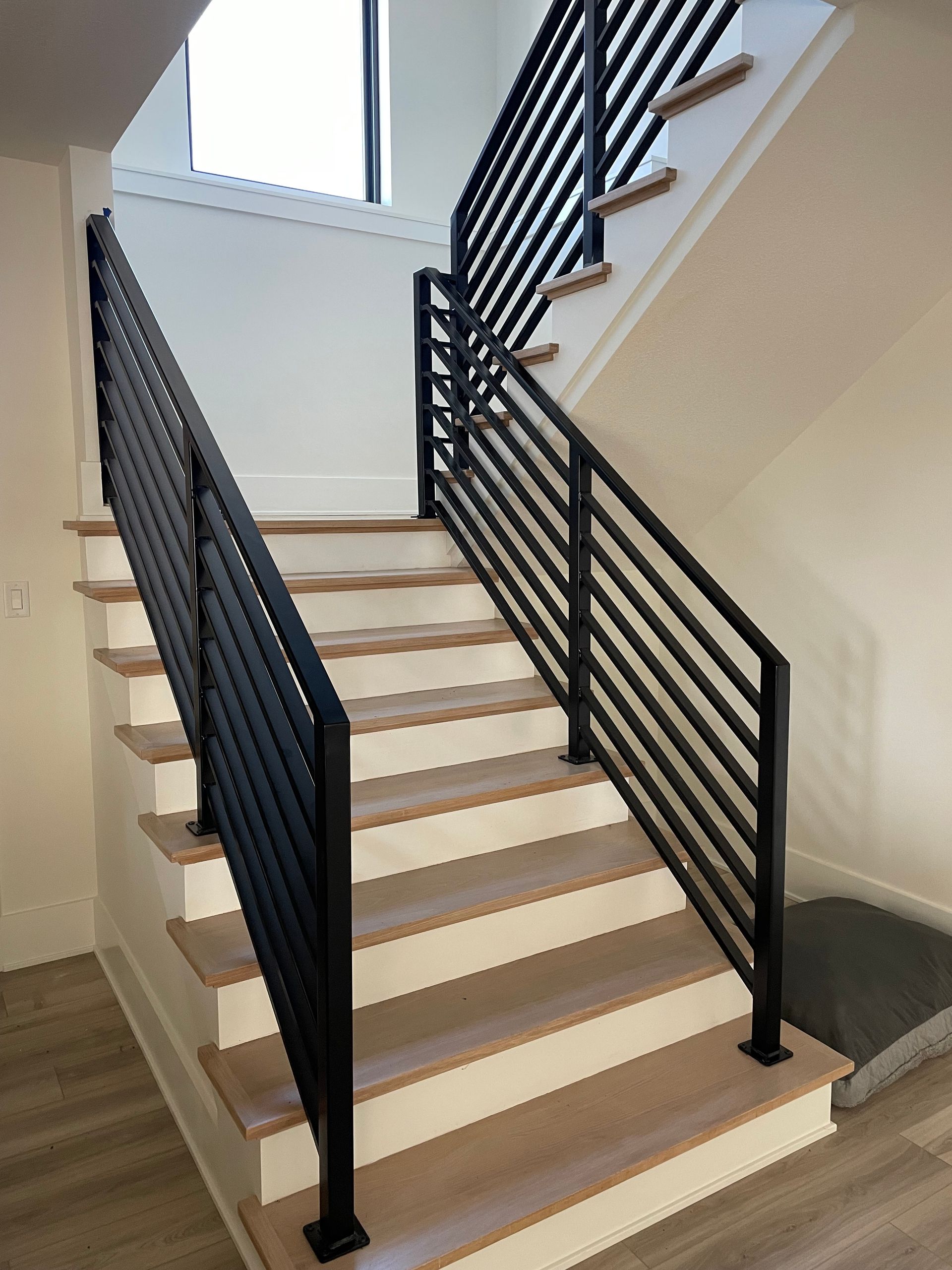 A staircase with a black railing and wooden steps