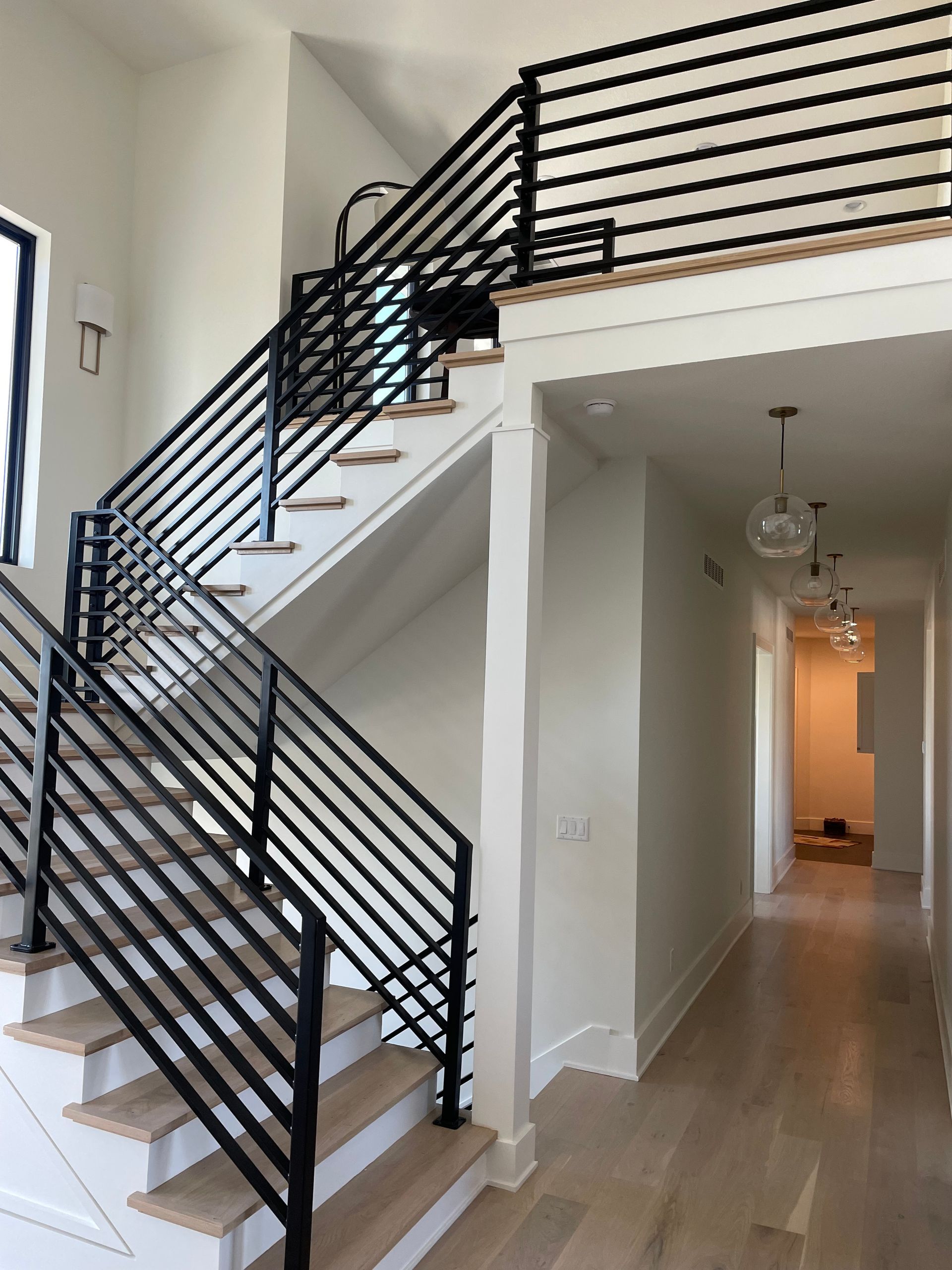 A staircase in a house with a black railing