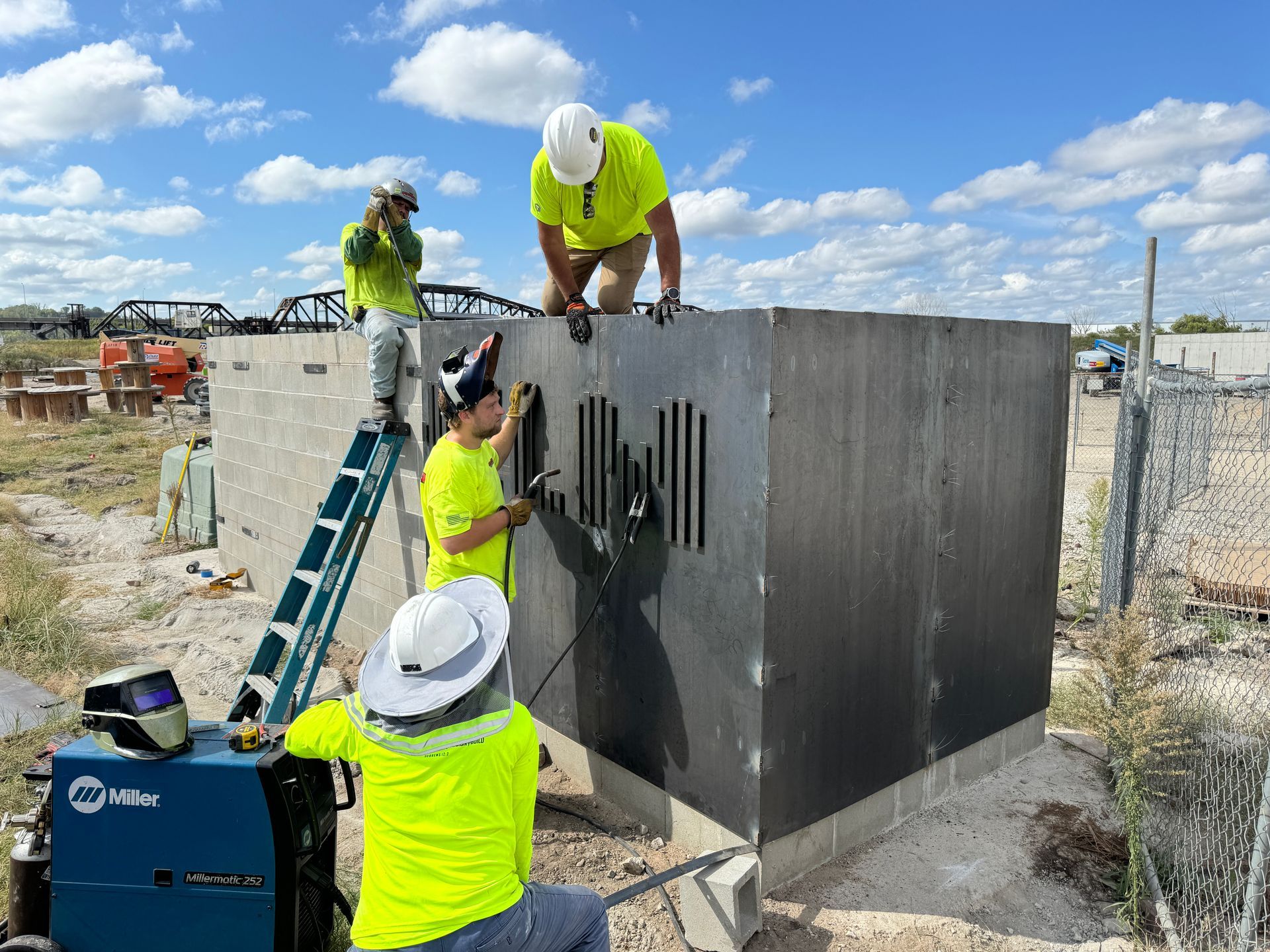A group of construction workers are working on a metal structure.