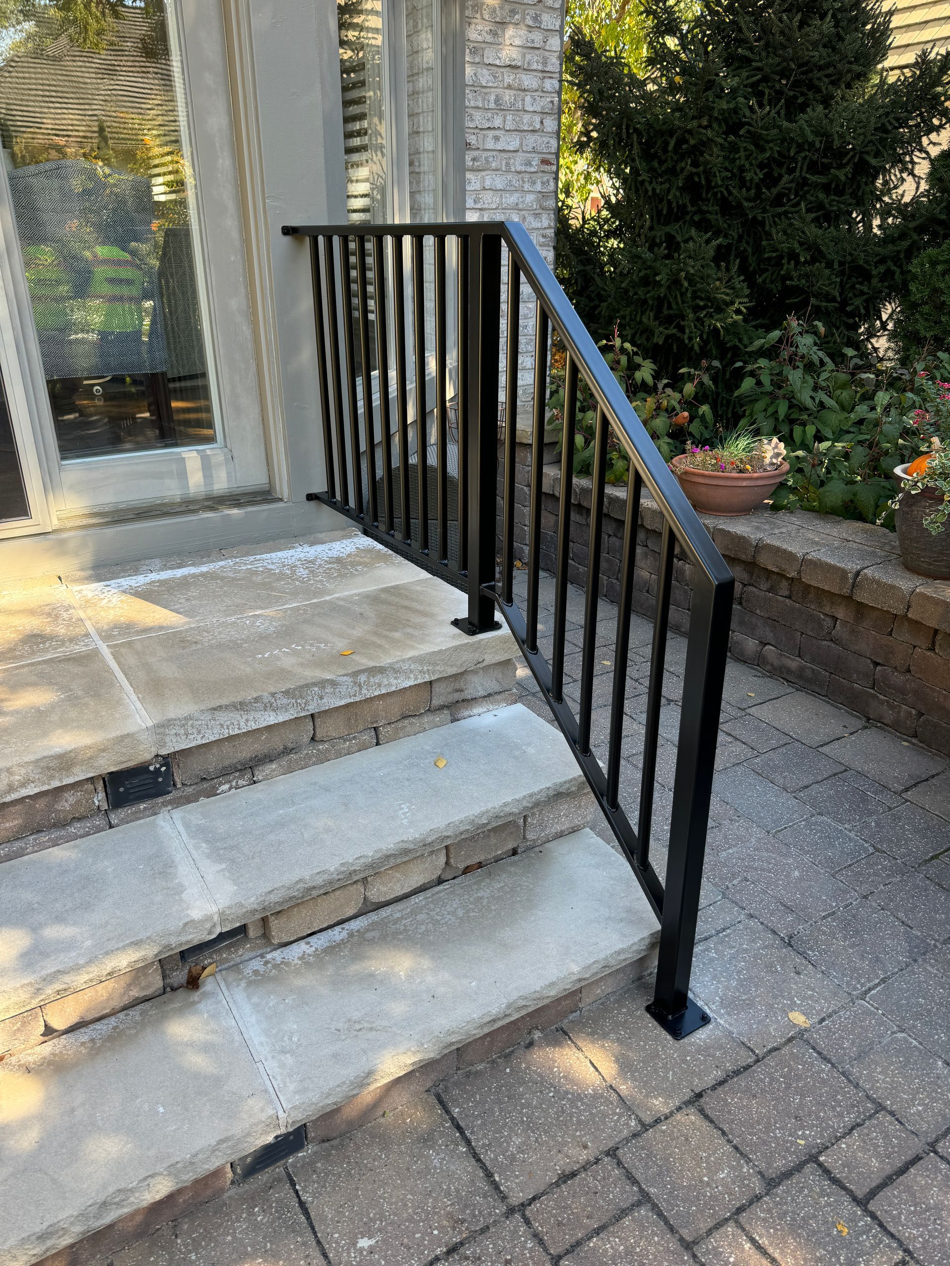 A black railing is sitting on top of a set of stairs.