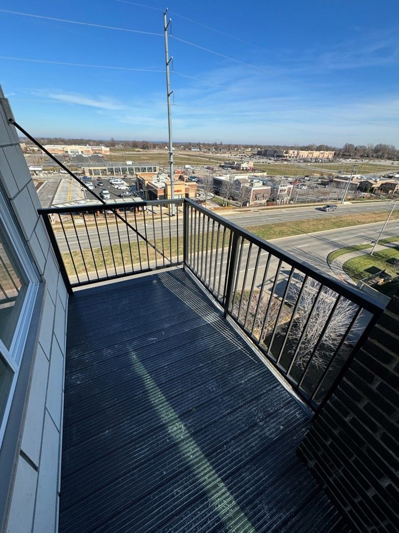 A balcony with a metal railing overlooking a city