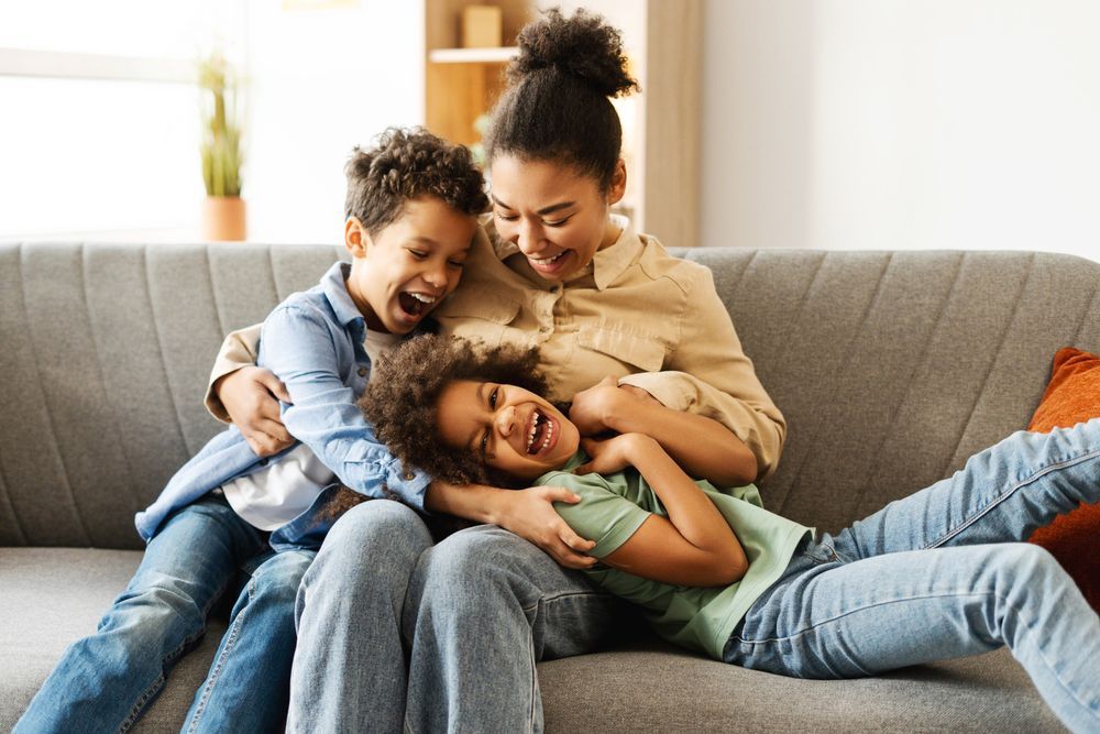 A woman and two children are sitting on a couch.