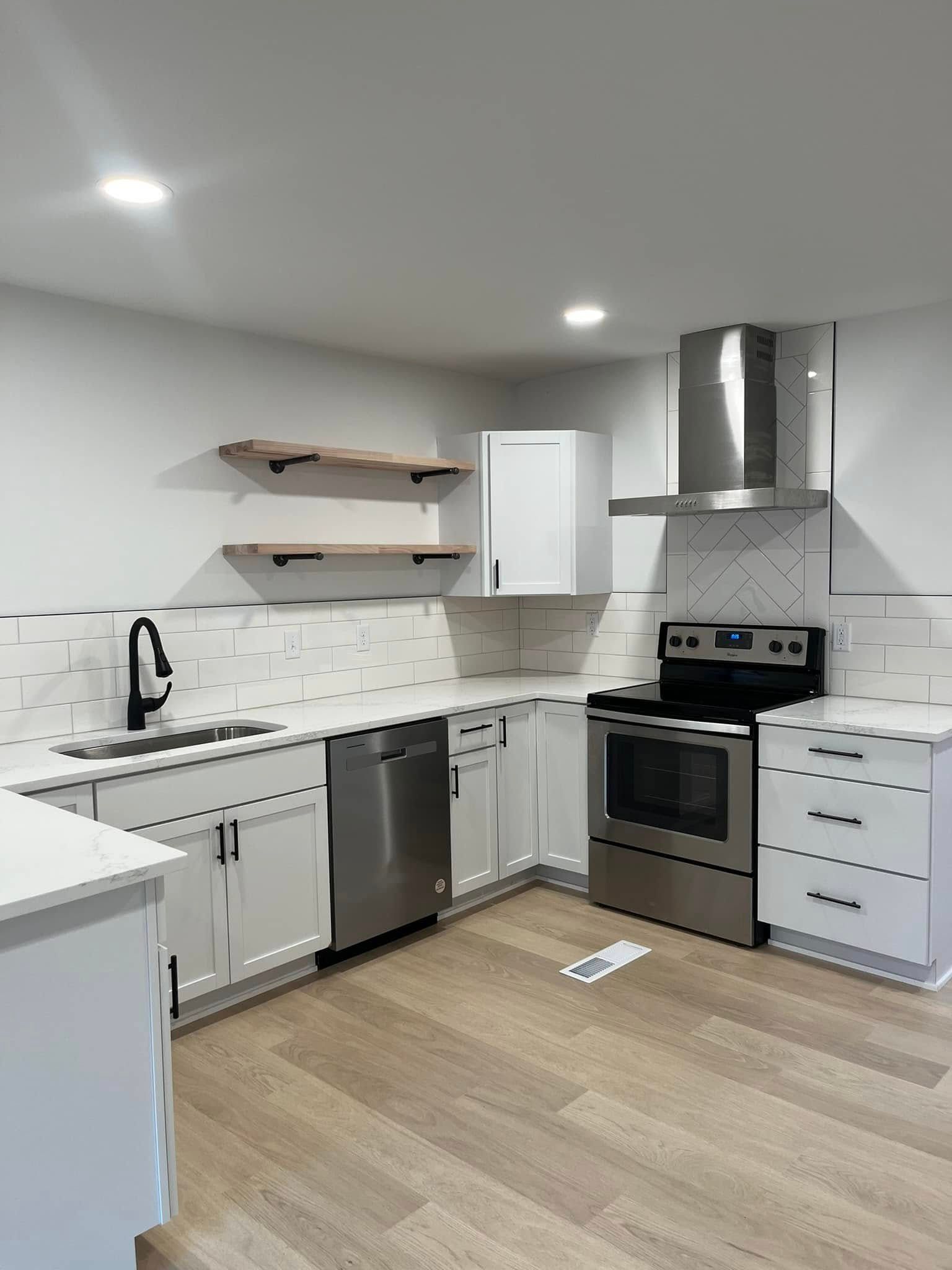 A kitchen with stainless steel appliances and white cabinets.