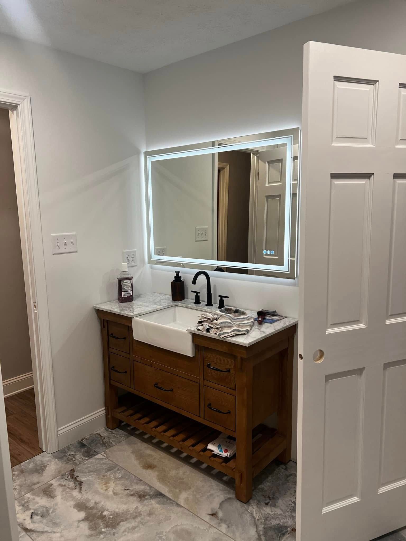 A bathroom with a sink , mirror , and drawers.