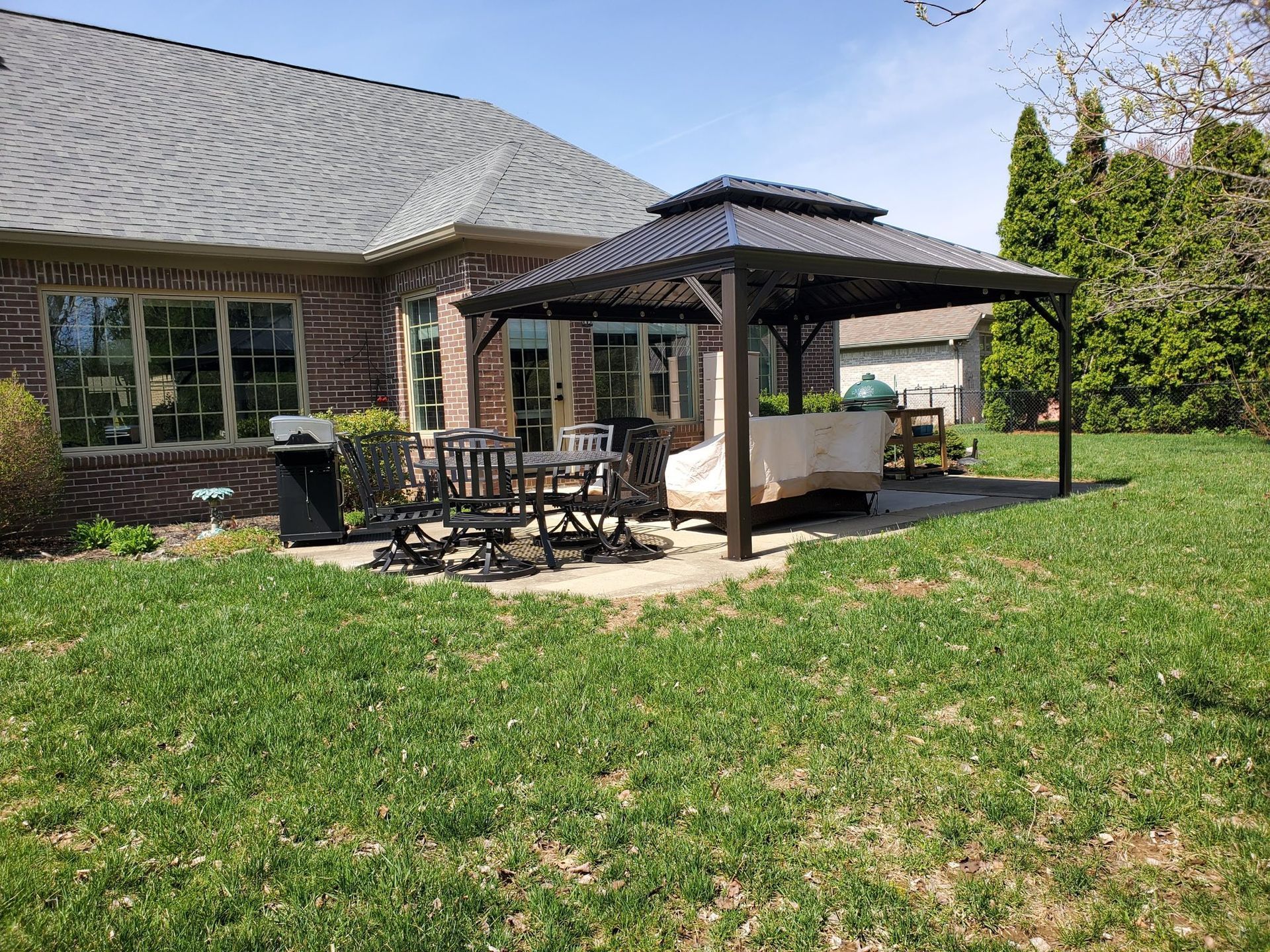 There is a gazebo in the backyard of a house.