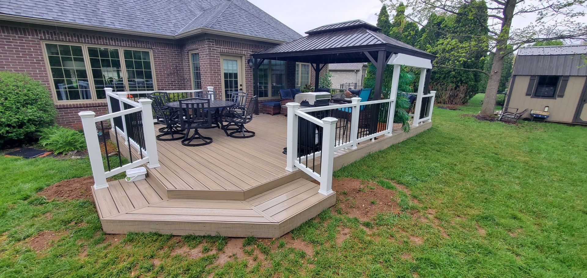 A large deck with a gazebo in the backyard of a house.
