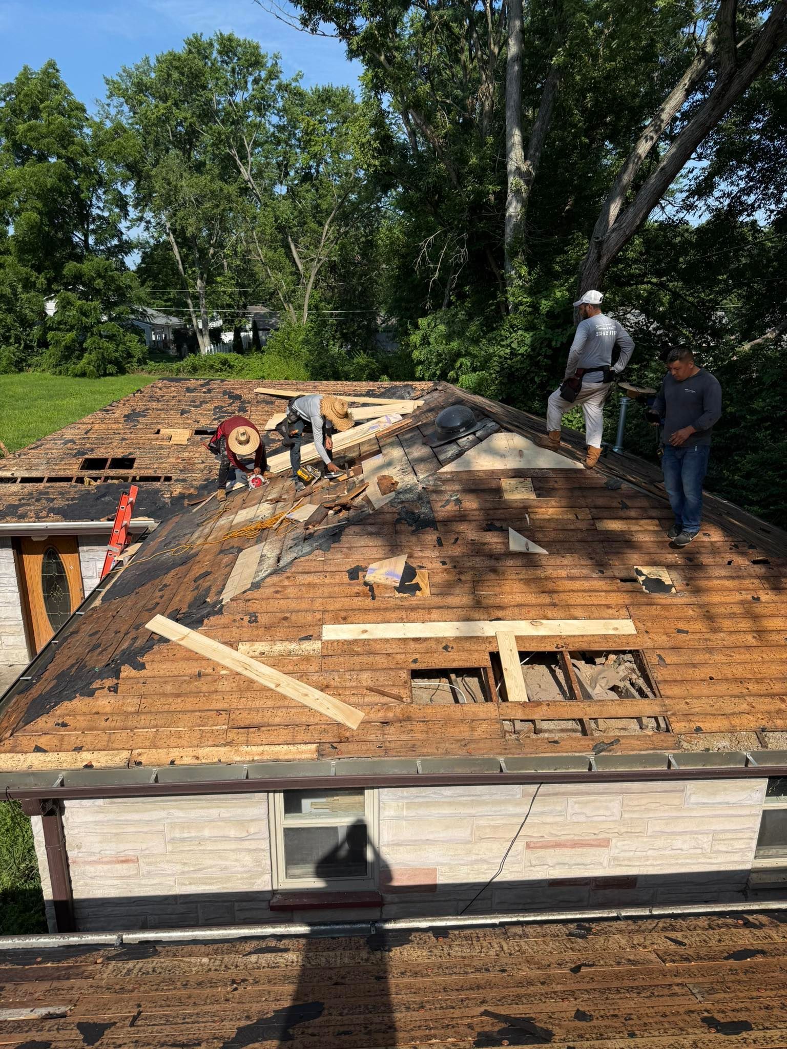 A group of men are working on the roof of a house.