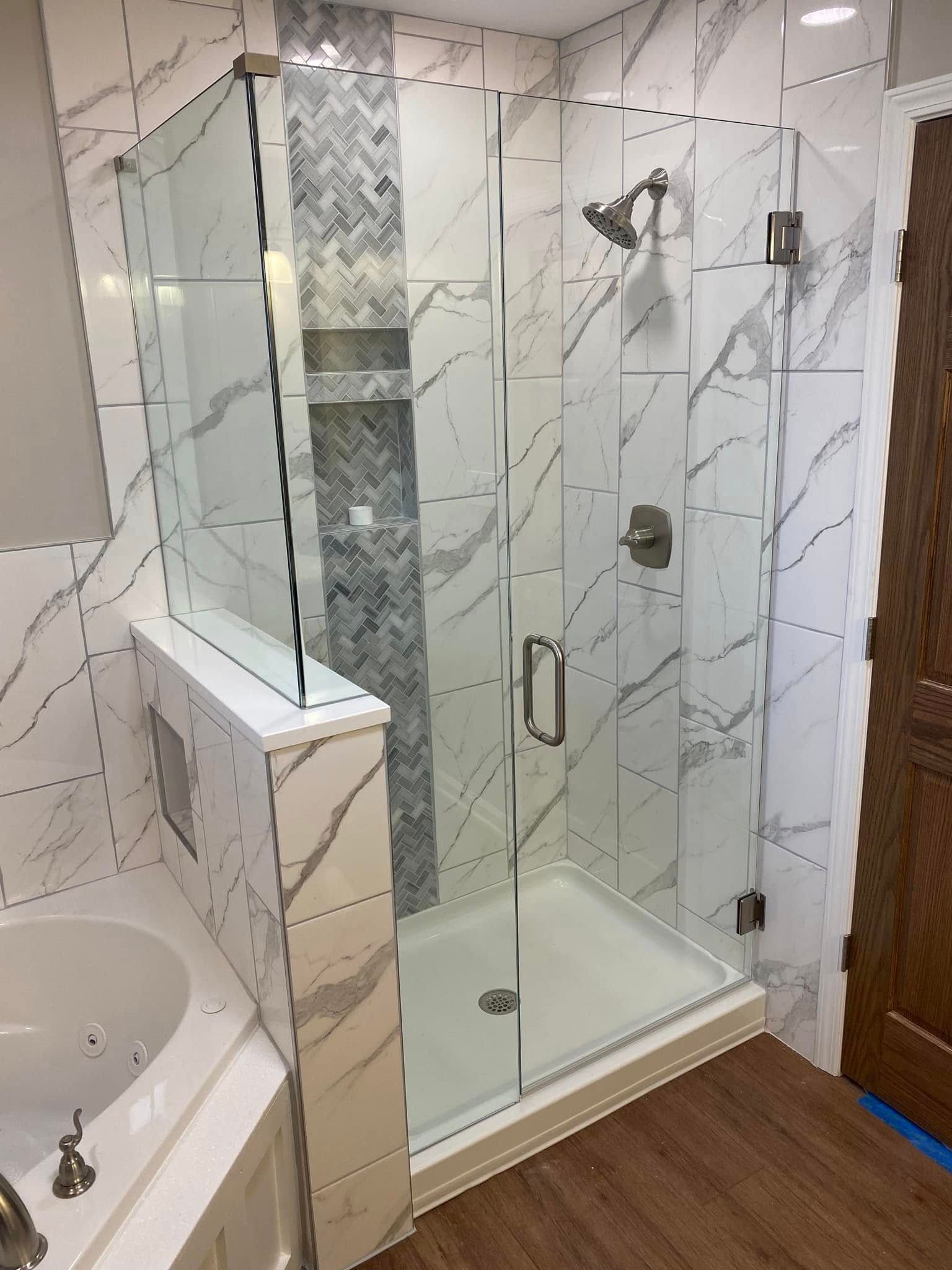 A bathroom with a walk in shower and a sink.