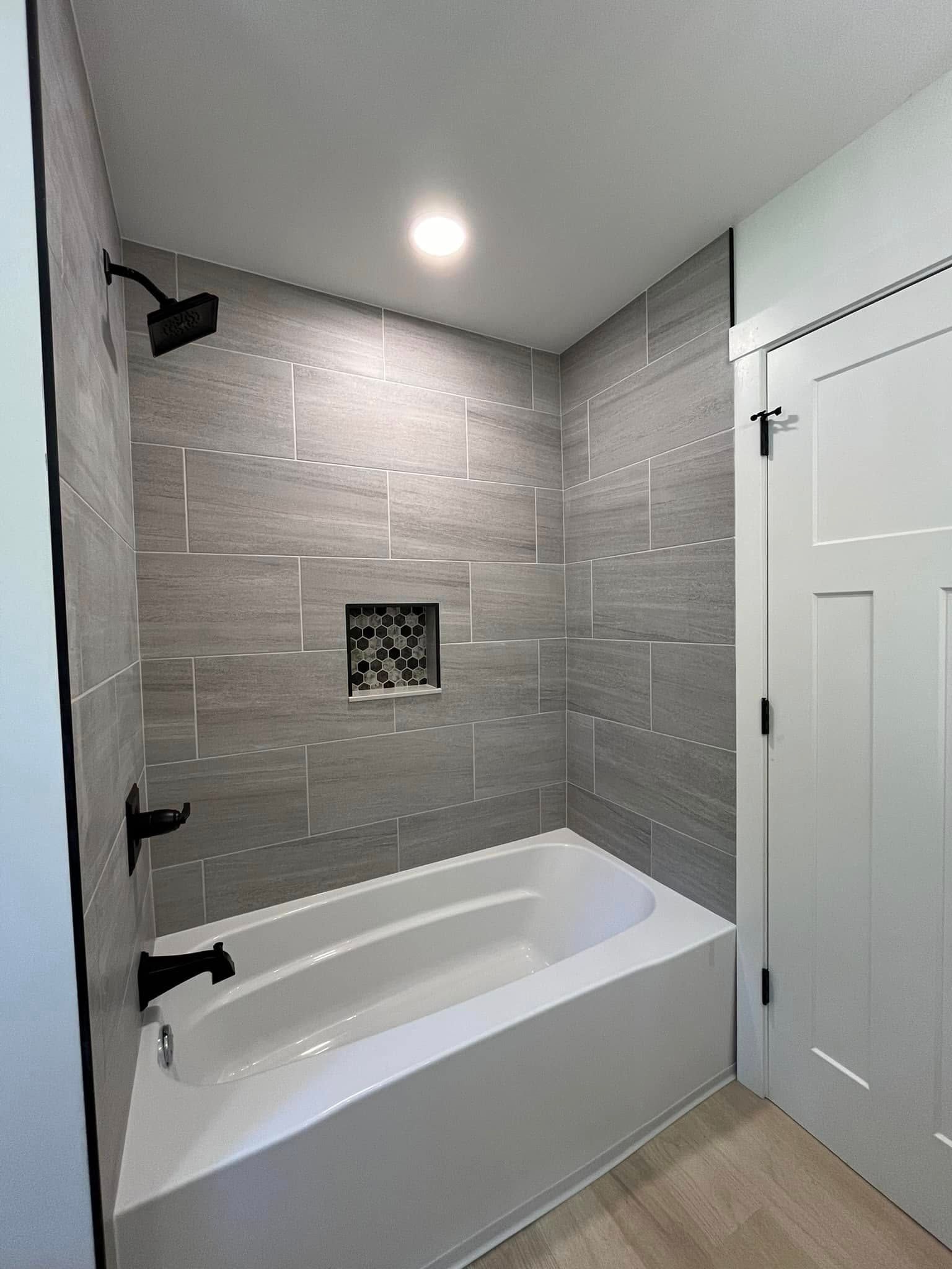 A bathroom with a bathtub and a shower.