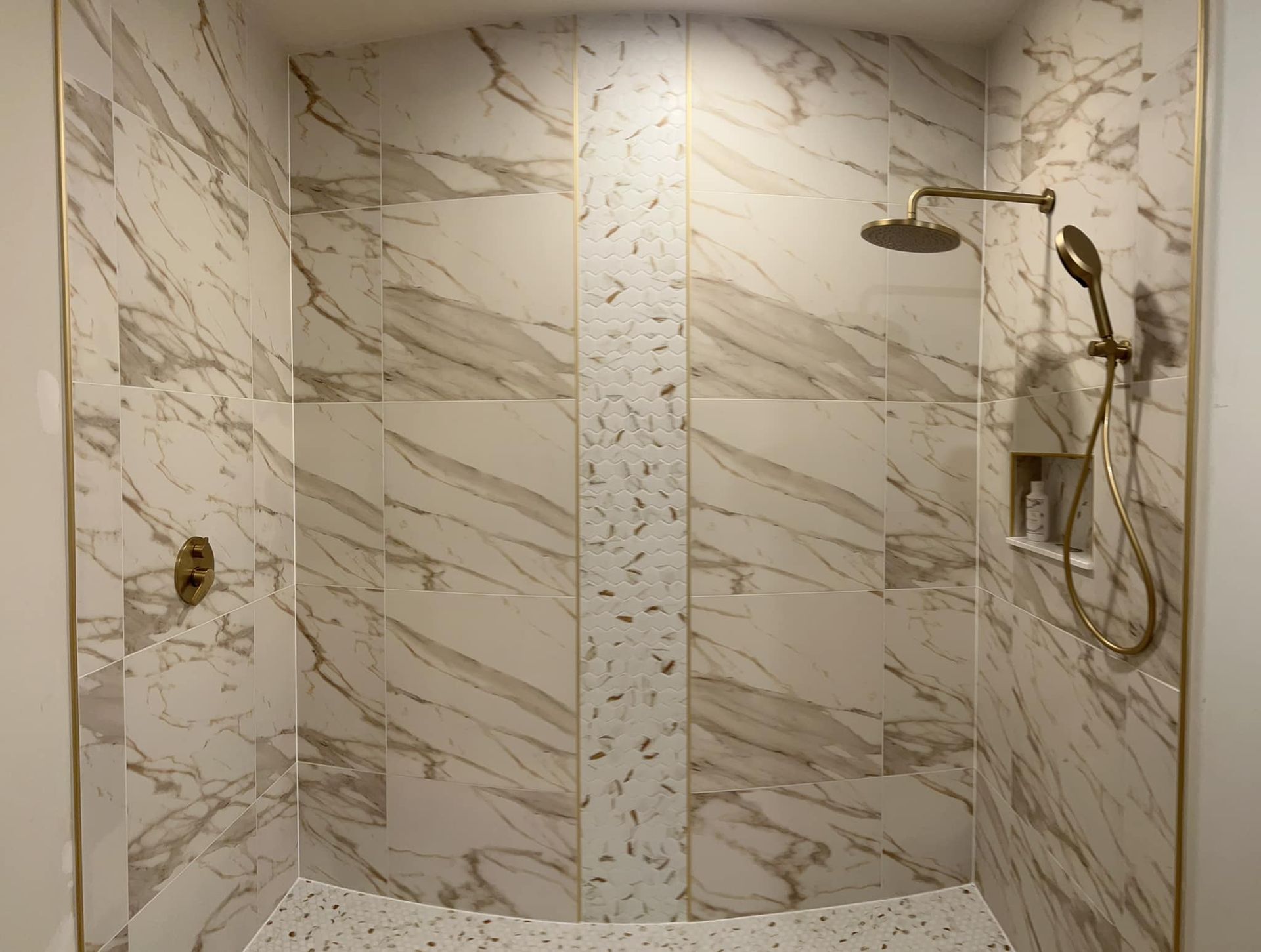 A shower with marble tiles and a shower head.