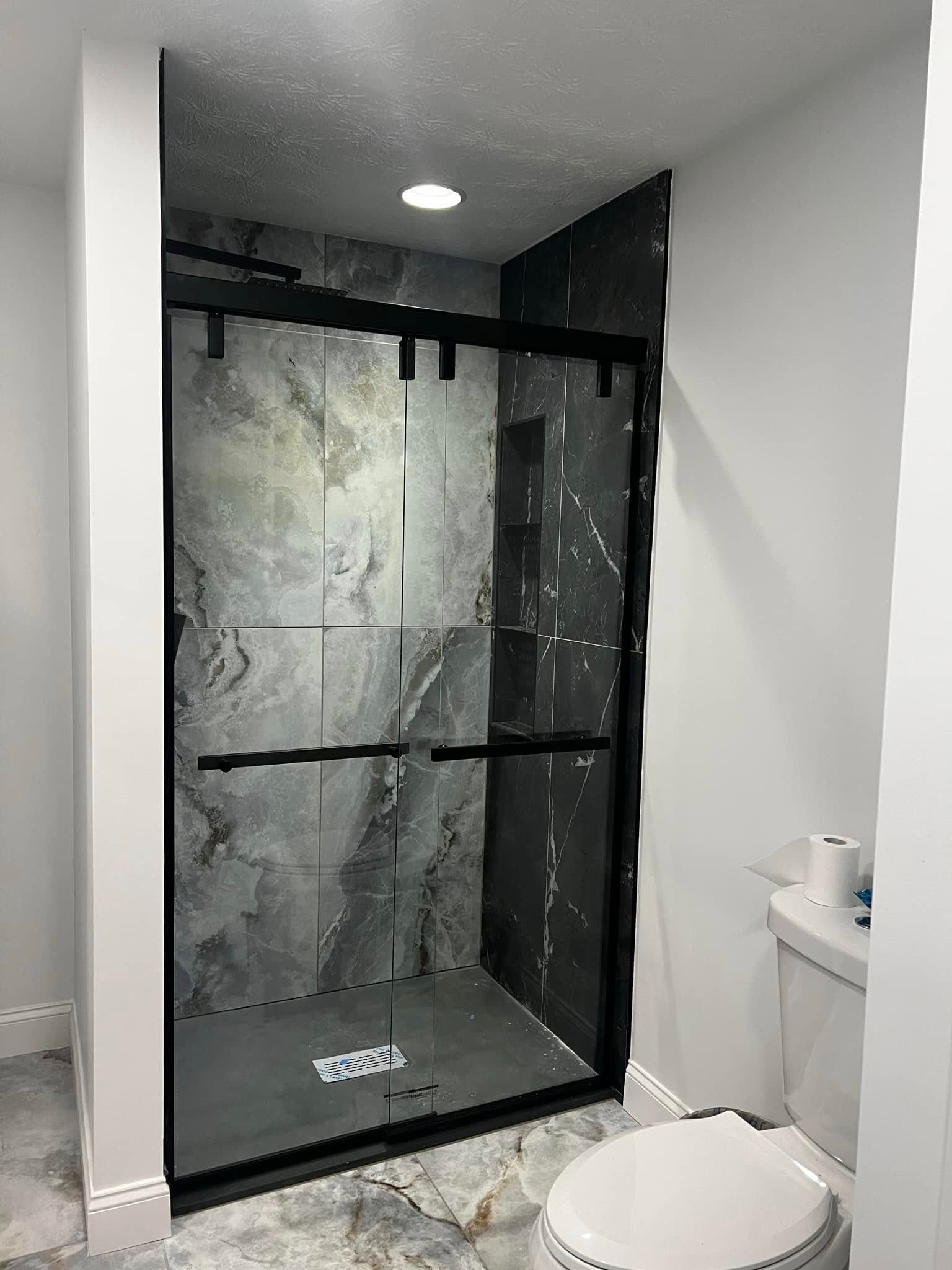 A bathroom with a walk in shower and a toilet.