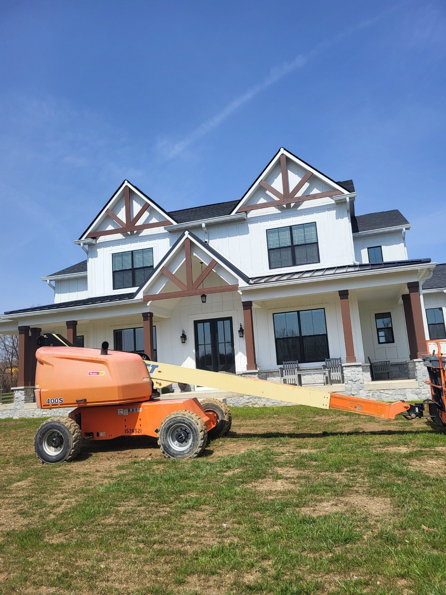 A large white house with a tractor parked in front of it.