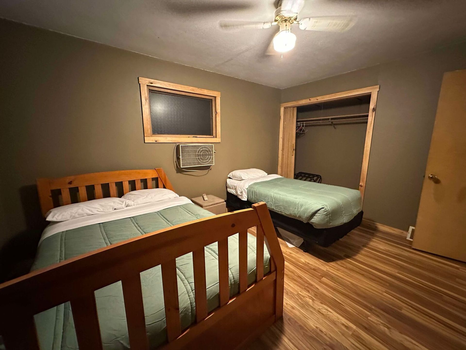 A bedroom with two beds and a ceiling fan.