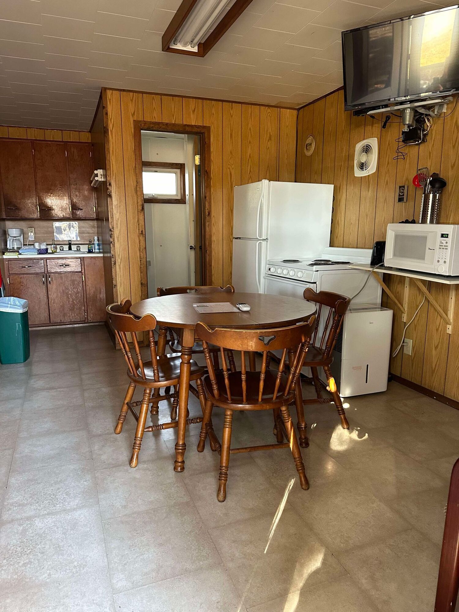 A kitchen with a table and chairs and a refrigerator