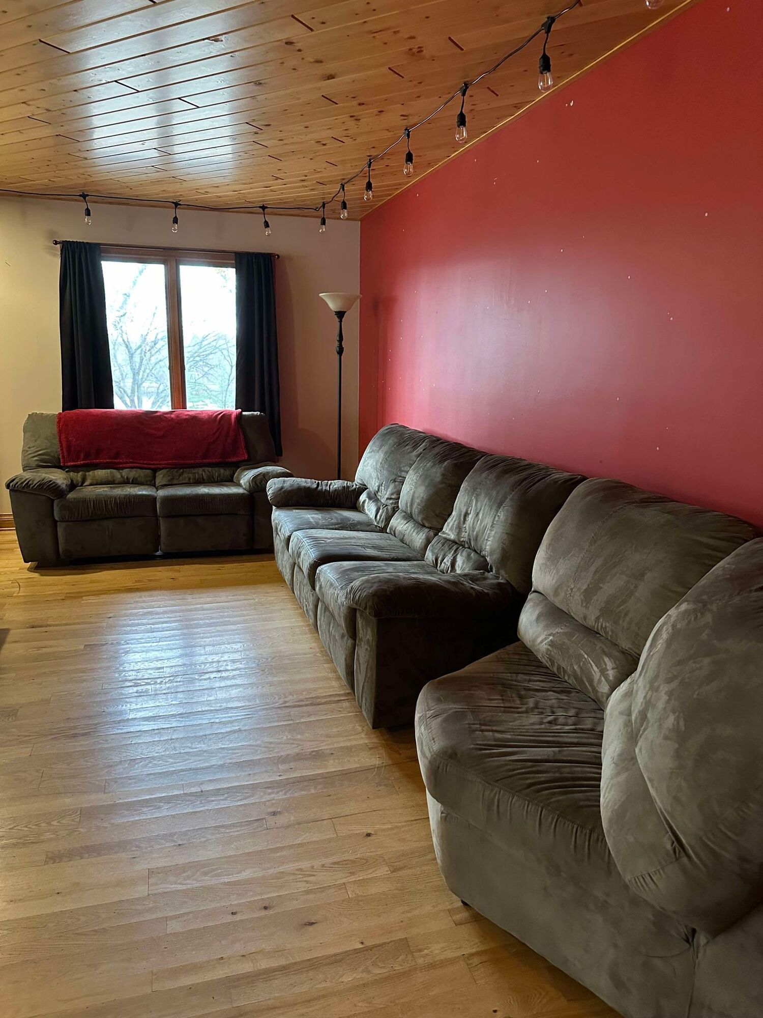 A living room filled with furniture and a red wall.