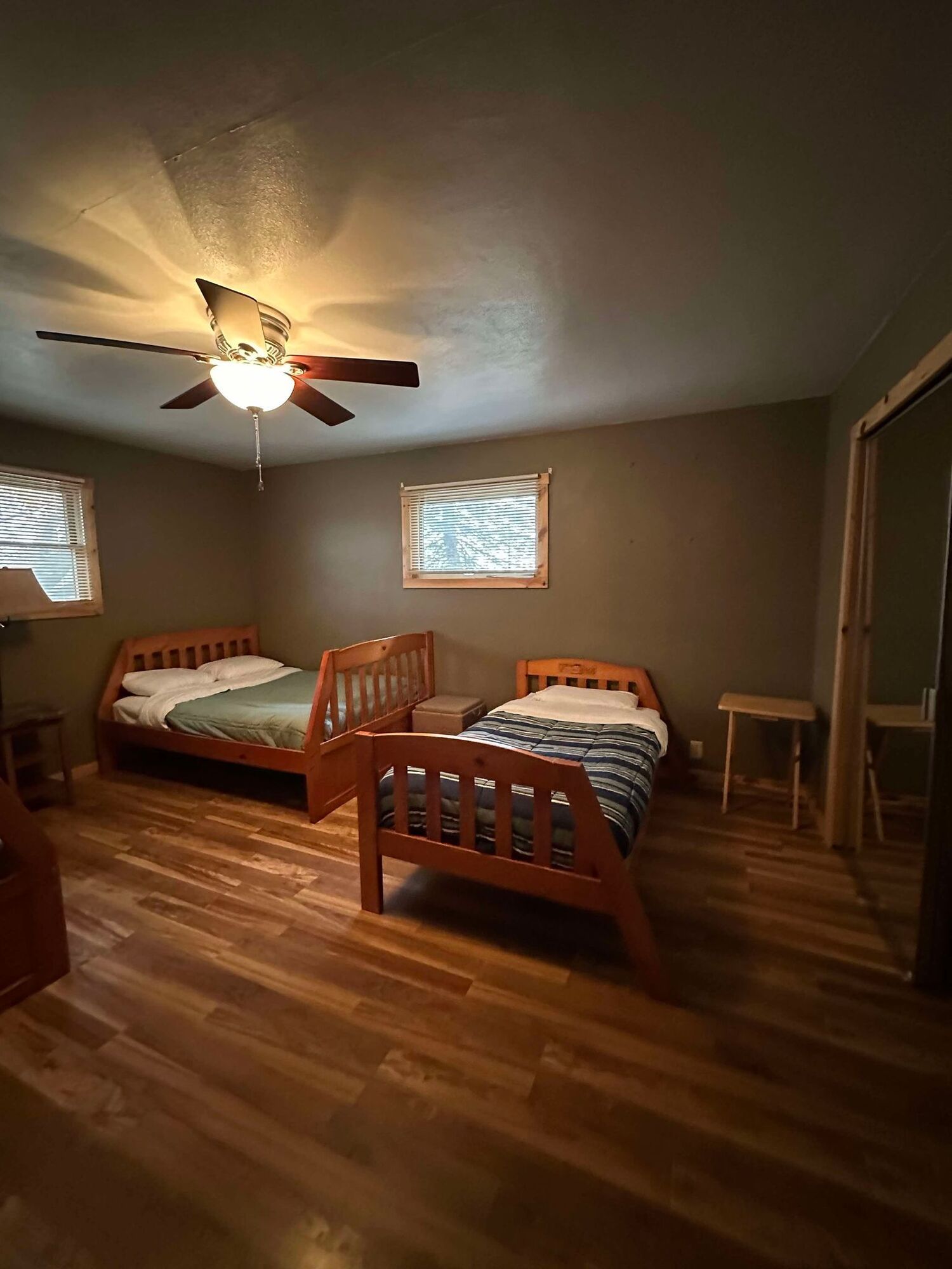 A bedroom with two beds and a ceiling fan.