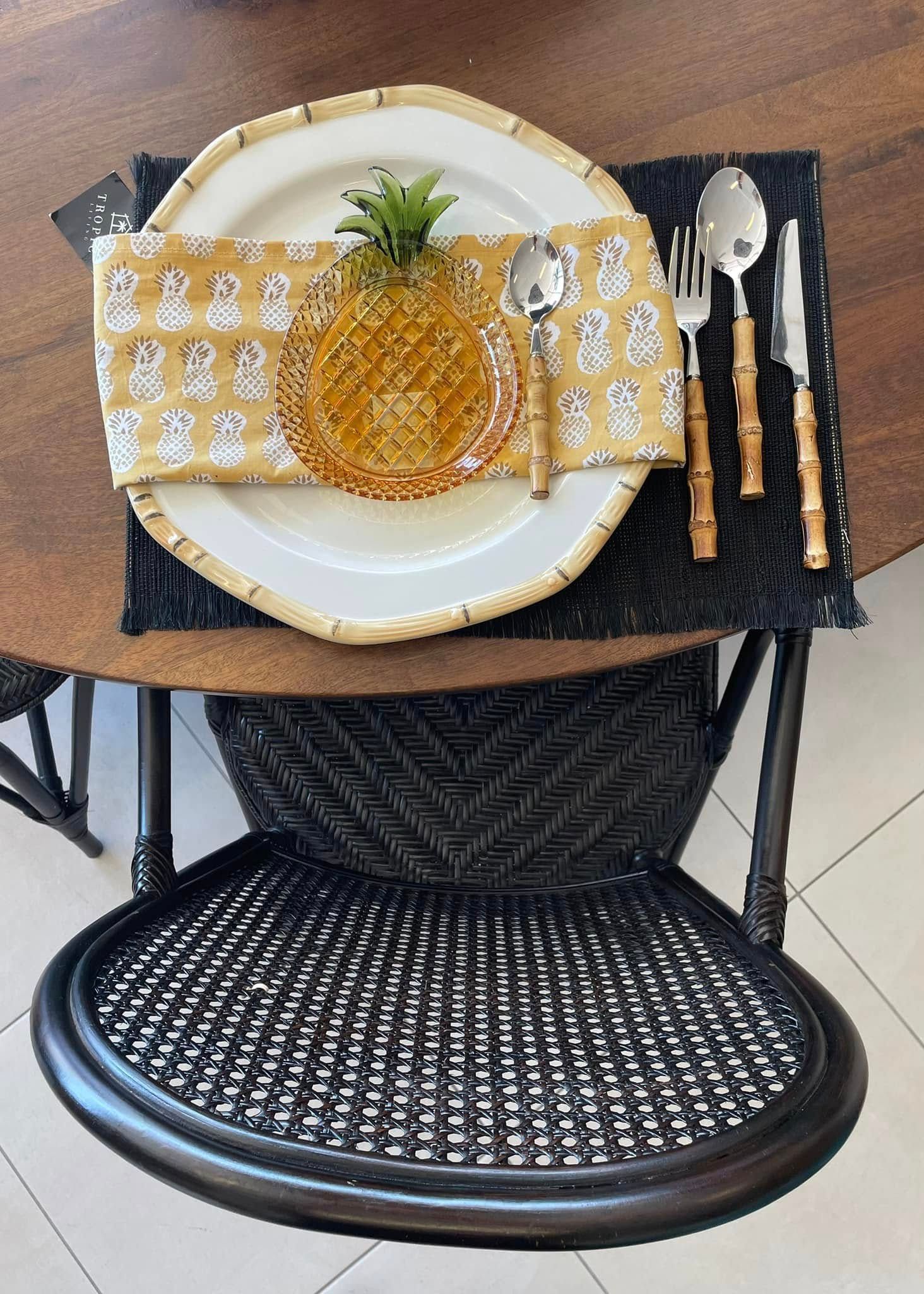 Place Setting with Pineapple Decor on Woven Chair and Table — Tropic Living - Cairns in Trinity Beach, QLD