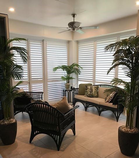 Sunroom with Black Wicker Furniture, Shutters, and Potted Palm Plants — Tropic Living in Port Douglas, QLD