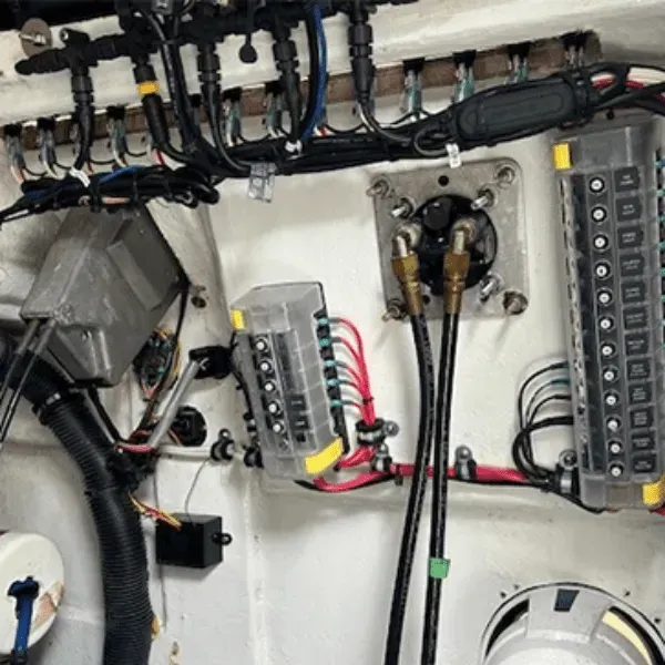 Boat's electrical panel with various wires, fuses, and connectors against a white background.