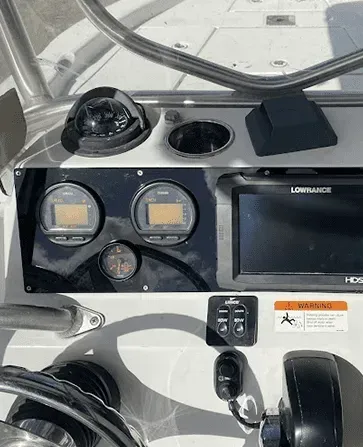 Boat dashboard with gauges, a compass, cupholder, navigation screen, and controls.