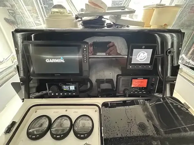 Boat dashboard with navigation equipment and gauges.