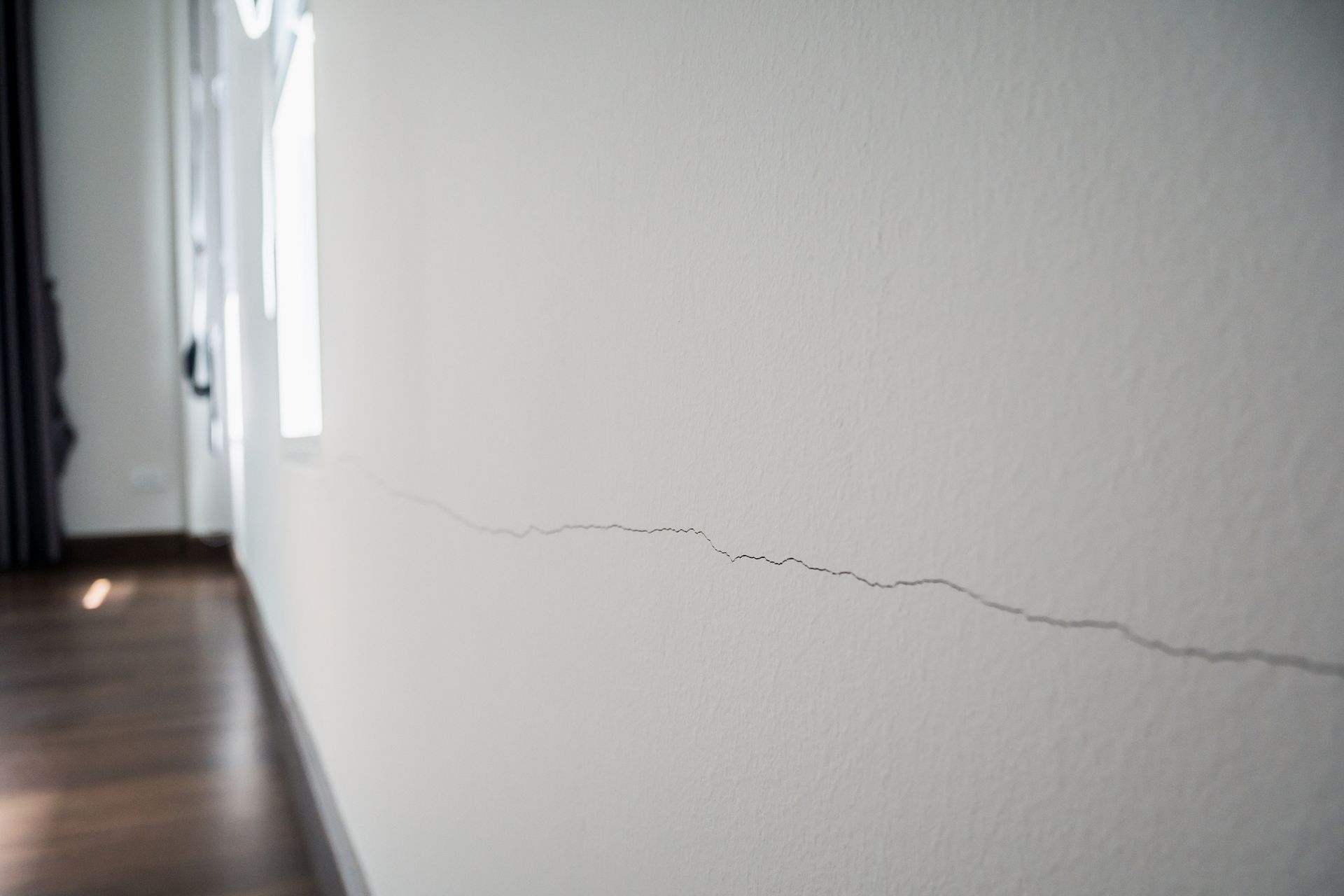 White wall with a long horizontal crack running across it.