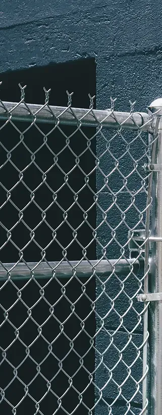 A close up of a chain link fence with a black background