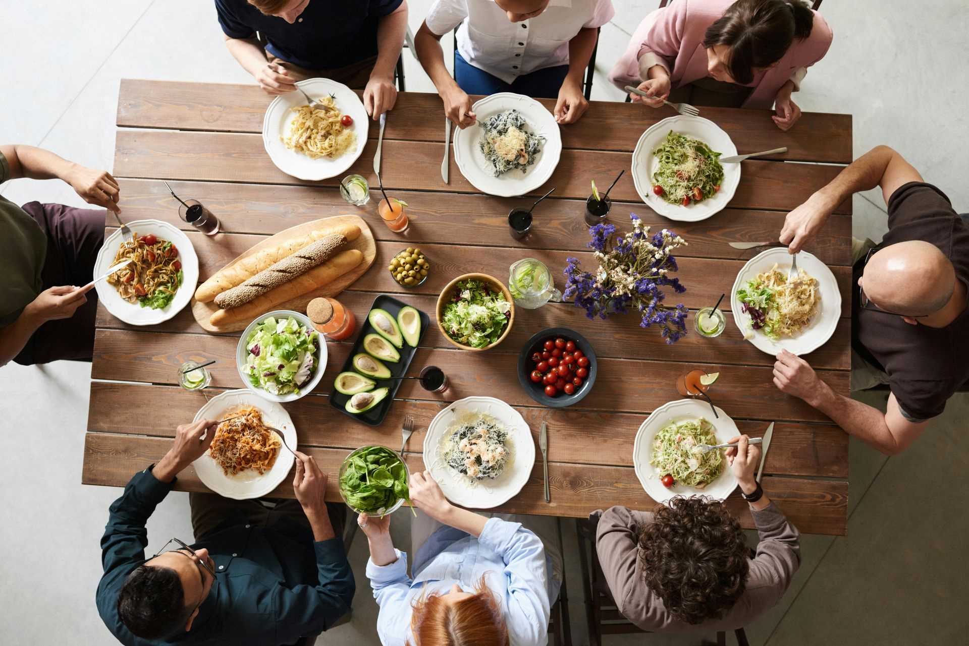Table filled with food and eight people seated - Mosaic Church, Freeport, FL