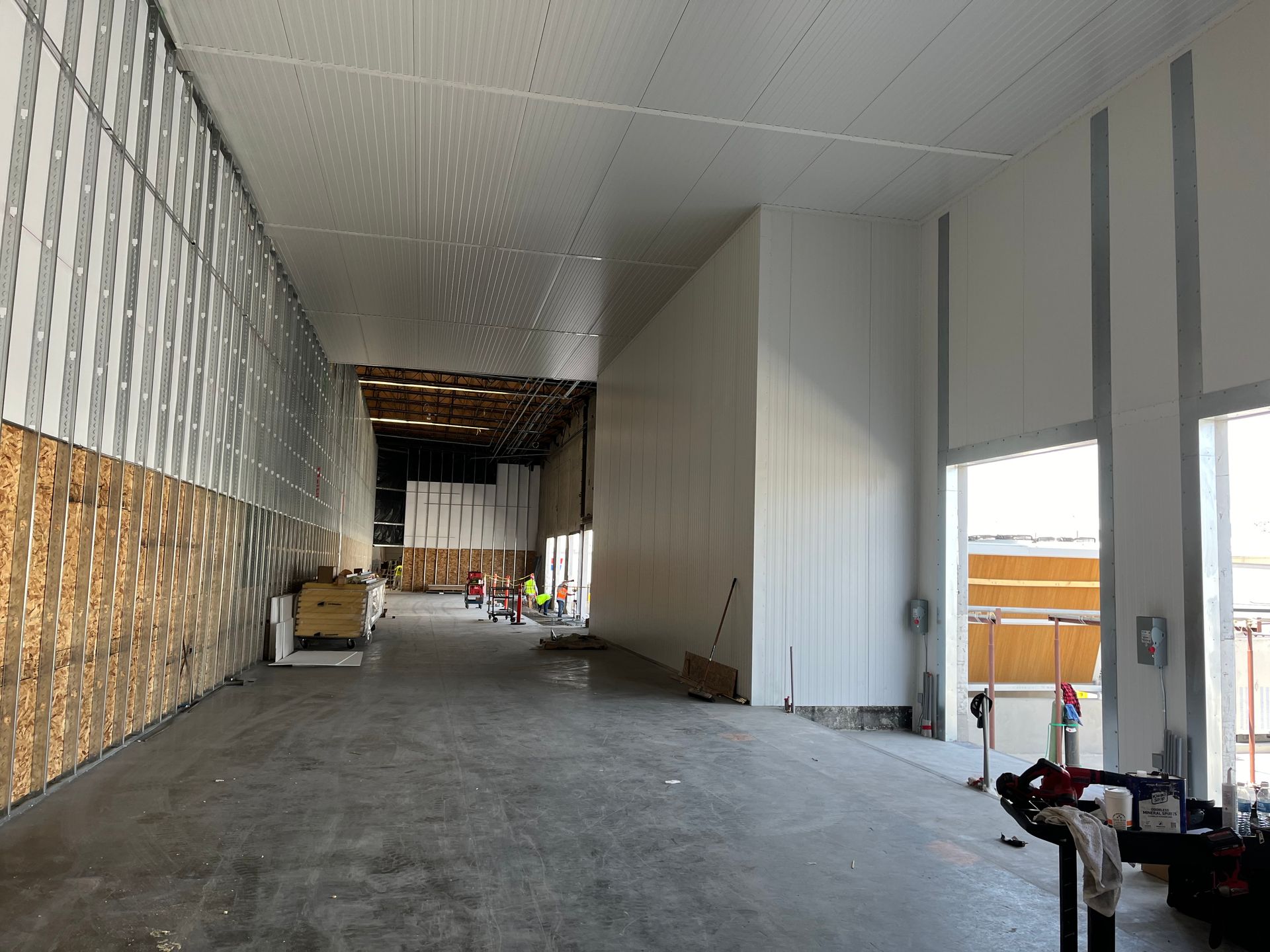 A large empty warehouse with white walls and a lot of windows.