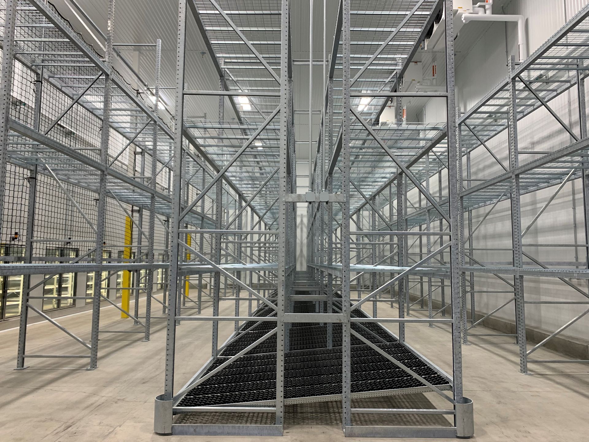 A large warehouse with lots of shelves and stairs.