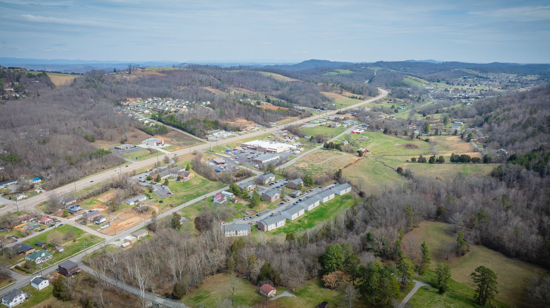 An aerial view of a small town surrounded by mountains and trees.