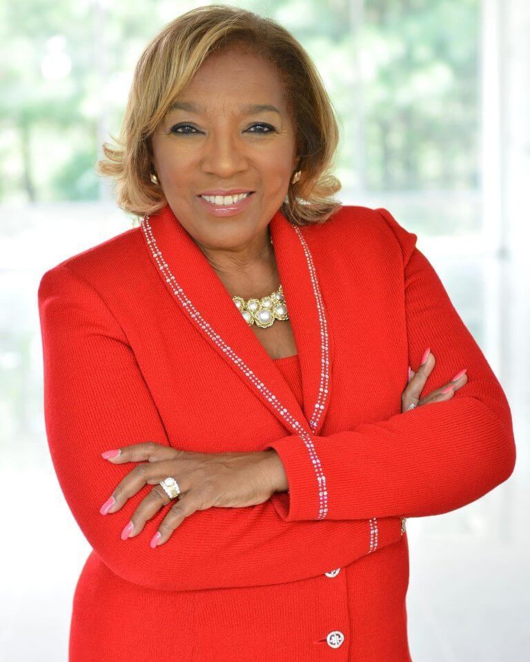 Woman in red suit with arms crossed, smiling. Woman in red suit with arms crossed, smiling.